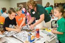 Stacey Hundley helps elementary school students make volcanoes