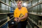 Mandy Wilson with bowling ball in library stacks