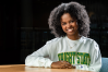A person sitting at a table, wearing a sweatshirt with "WRIGHT STATE" across the front.