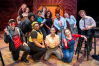 A group of theatre performers post for a group photograph.