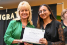 A student stands with the Dean of the College of Health, Education and Human Services, both holding a certificate.