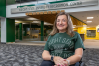 A woman in a wheelchair wearing a Wright State shirt poses outside of the Wright State University Recreation Center.