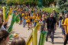 A group of students in Wright State t-shirts walk down a sidewalk, being cheered on by staff and faculty members.