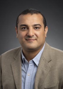A man in a suit posing for a professional headshot.