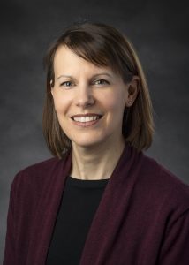 A woman in business attire posing for a professional portrait.