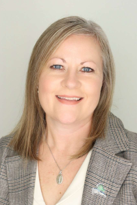 A woman in business attire posing for a professional portrait.