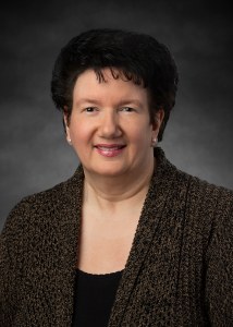 A woman in business attire posing for a professional portrait.