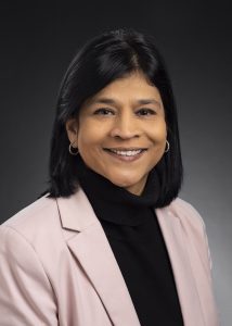 A woman in business attire posing for a professional portrait.