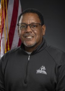 A man in a Wright State jacket posing for a professional portrait.