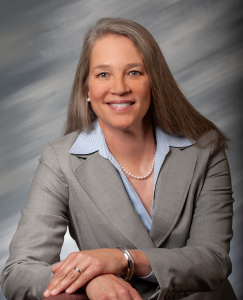 A woman in business attire posing for a professional portrait.