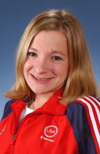 A person in a TEAM USA zip up jacket poses for a professional portrait.