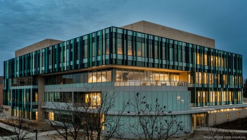A building with large windows set against a darkening sky.