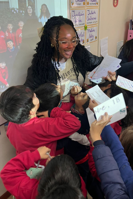 A teacher receives letters from a group of students in a classroom setting.