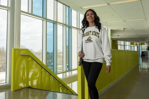 Monica walking through the halls of the Student Success building. 