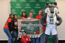 Six students stand alongside Wright State's wolf mascot, holding a sign that says "Future Teachers Day."